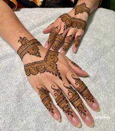 two hands with henna tattoos on them