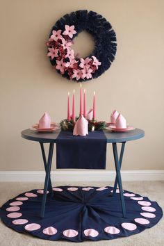 A navy blue table setting featuring pink candles and matching pink and navy Christmas decorations for a stylish holiday look. Pink Christmas Decorations