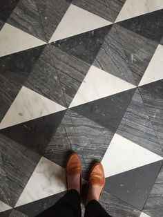 a person standing on top of a black and white tiled floor