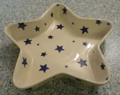 a ceramic star dish with blue stars on it's side sitting on a counter