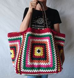 a woman is holding a crocheted bag