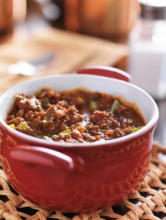 a red pot filled with food sitting on top of a table