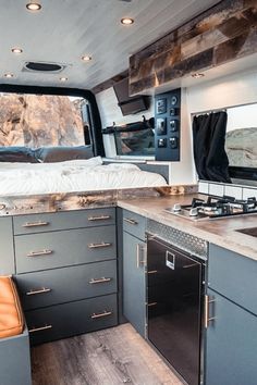 the interior of a camper with an oven and sink