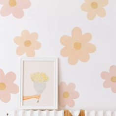 a baby's room with flowers painted on the wall and crib next to it