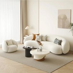 a living room filled with white furniture and lots of pillows on top of the couches