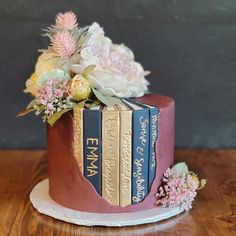 a cake decorated with books and flowers on a table