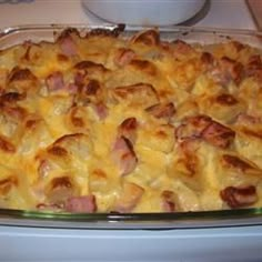 a casserole dish with ham and cheese in it sitting on a counter top