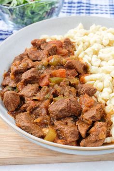 meat and pasta in a white bowl on a table