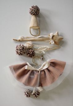 three pieces of cloth with bows and flowers attached to the back of each piece, on a white surface