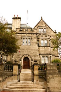 an old building with stairs leading up to the front door and steps down to the entrance