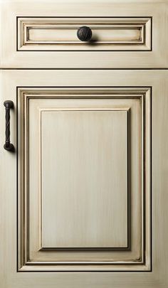 an old white cabinet door with black knobs