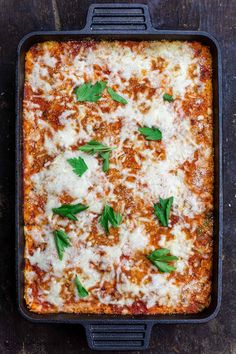 a square casserole dish filled with meat and cheese, garnished with parsley