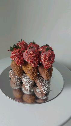 three donuts are stacked on top of each other with strawberries and sprinkles