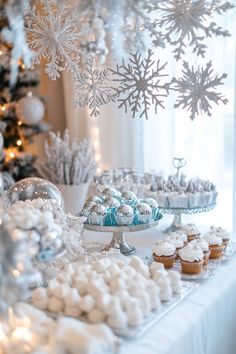 a table topped with cupcakes and muffins next to a christmas tree