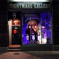 a store front that has some lights on it and there are two mannequins in the window