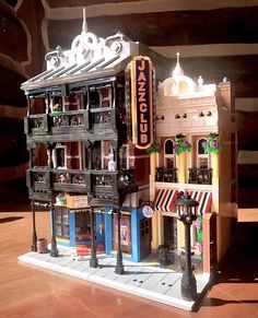 a model of a building made out of legos on a wooden floor in front of a store