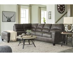 a living room filled with furniture and a large clock mounted to the wall above it