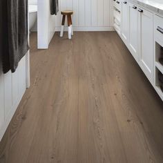 a kitchen with white cabinets and wood floors