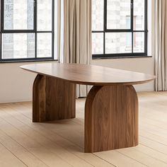 an image of a wooden table in the middle of a room with windows and curtains