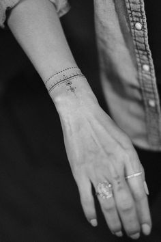 black and white photograph of a woman's wrist with a star tattoo on it