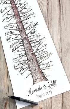 a drawing of a tree with names on it and a pen sitting next to it