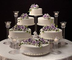 a table topped with lots of white and purple cakes