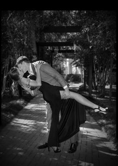 a man and woman kissing on the sidewalk