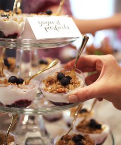 desserts are displayed on three tiered trays with forks and spoons in them