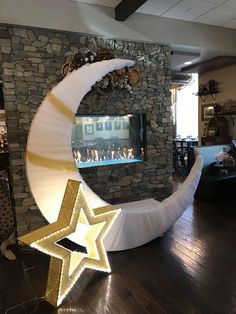 a large white moon and star decoration in front of a stone wall with a fireplace