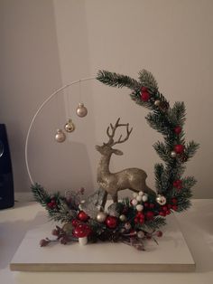 a christmas decoration is displayed on a white surface with red and silver ornaments around it