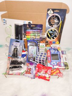 a box filled with assorted toys and games on top of a white fur covered floor