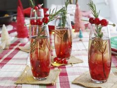 three glasses filled with liquid sitting on top of a red and white checkered table cloth