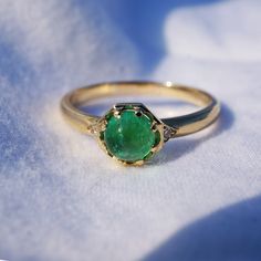 A beautiful Emerald cabochon set in 14k yellow gold, with two diamond accents.  This ring is size 6.25. Other sizes available.