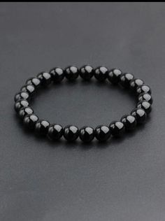 This black pearl bracelet is an elegant and timeless accessory for men. It is made of smooth and shiny black beads which are connected by an elastic thread. This bracelet is perfect for completing a casual or formal look and adding a touch of sophistication to your style. Mens Bracelet Beads, Classic Black Bracelets With 8mm Beads, Classic Black Beaded Bracelets As Gift, Classic Black Beaded Bracelets, Black Pearl Bracelet With Round Beads, Black Pearl Bracelet With Round Beads For Gift, Black Pearl Bracelet, Elastic Thread, Men's Bracelet