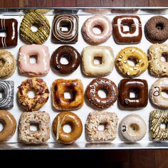 a box filled with lots of different kinds of doughnuts on top of each other