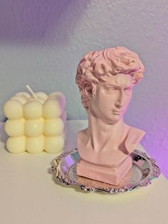 a pink busturine sitting on top of a table next to some white balls