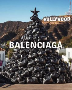 a large christmas tree made out of black bags with the hollywood sign in the background