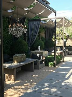 an outdoor seating area with chandelier and stone benches in the middle of it