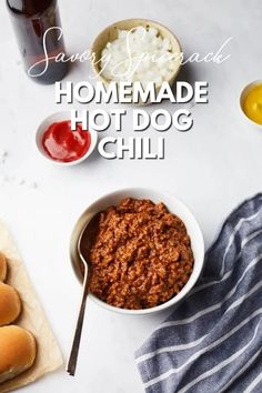 homemade hot dog chili in a white bowl next to buns and ketchup