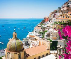 an aerial view of the ocean and buildings in positanoa, italy on a sunny day