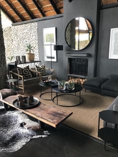 a living room filled with furniture and a large mirror on the wall above it's fireplace