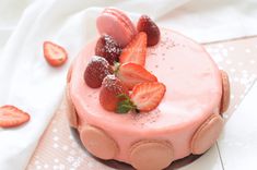 a strawberry cake with powdered sugar and fresh strawberries on the top, sitting on a white cloth