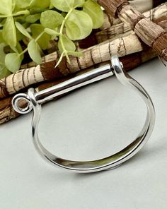 a close up of a metal object on a table with some flowers in the background