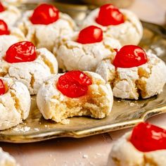 small pastries with cherries are on a gold platter, ready to be eaten