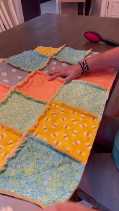 someone is making a patchwork quilt on the table