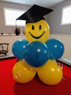 balloons in the shape of a smiley face with a graduation cap on top