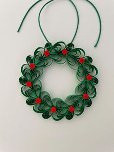 an ornament made out of green paper with red flowers