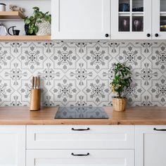 a potted plant sitting on top of a wooden counter next to a kitchen sink