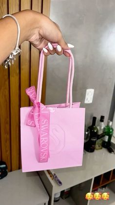 a person holding a pink shopping bag in their hand