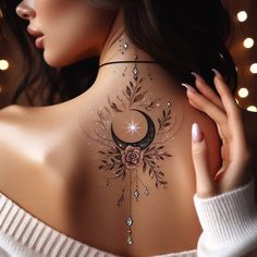 the back of a woman's neck with a crescent and flower tattoo on it